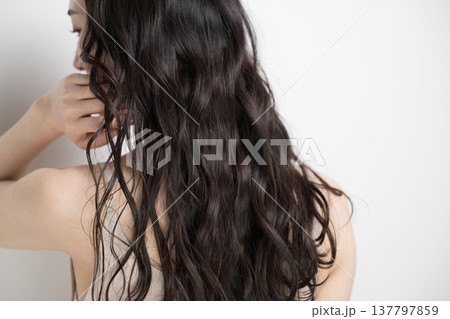 白背景に髪をなびかせるロングヘアでパーマの女性 顔無しの後ろ姿 白背景に髪をなびかせるロングヘアでパーマの女性 顔無しの後ろ姿 137797859