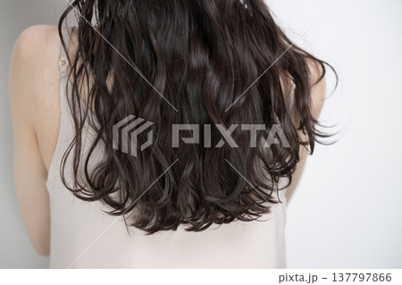 白背景に髪をなびかせるロングヘアでパーマの女性 顔無しの後ろ姿 白背景に髪をなびかせるロングヘアでパーマの女性 顔無しの後ろ姿 137797866