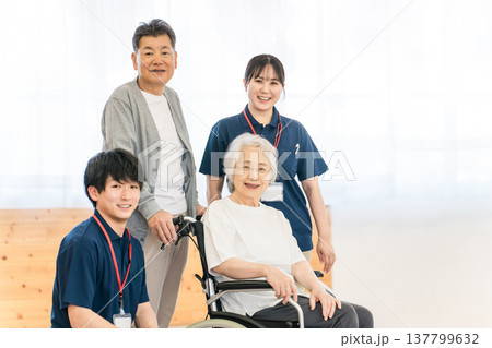 車椅子に乗るシニア女性・シニア夫婦と作業療法士・理学療法士の男女職員 137799632
