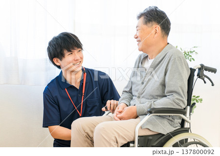 車椅子のシニア男性患者と介護士・ケアマネージャーの男性スタッフ(認知症・リハビリ) 車椅子のシニア男性患者と介護士・ケアマネージャーの男性スタッフ(認知症・リハビリ) 137800092