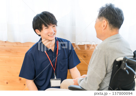 車椅子のシニア男性患者と介護士・ケアマネージャーの男性スタッフ(認知症・リハビリ) 車椅子のシニア男性患者と介護士・ケアマネージャーの男性スタッフ(認知症・リハビリ) 137800094