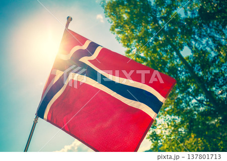 Norwegian flag fluttering against blue sky Norwegian flag fluttering against blue sky 137801713