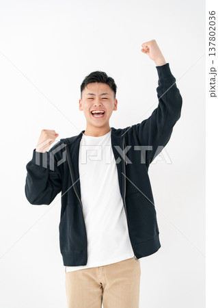 若い男性　カジュアル　ガッツポーズ 137802036