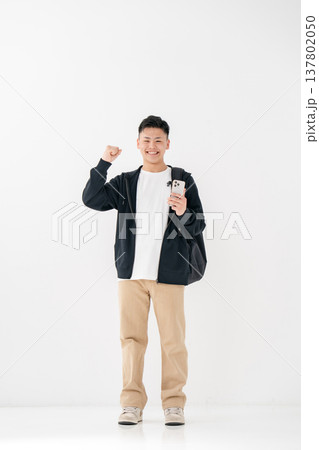 若い男性 カジュアル スマホ 全身 ガッツポーズ 若い男性 カジュアル スマホ 全身 ガッツポーズ 137802050