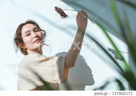 一輪のガーベラの花を持つ女性 一輪のガーベラの花を持つ女性 137802171