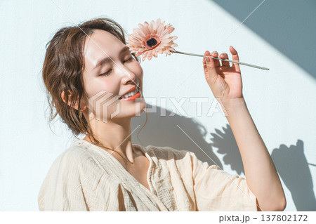 一輪のガーベラの花を持つ女性 137802172