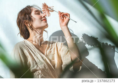一輪のガーベラの花を持つ女性 137802173