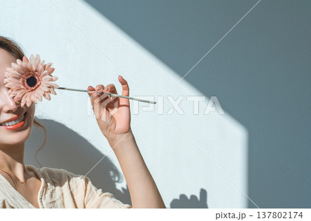 一輪のガーベラの花を持つ女性 137802174