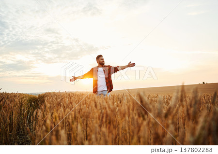 Freedom conception, hands to the sides. Male farmer is on the wheat agricultural field Freedom conception, hands to the sides. Male farmer is on the wheat agricultural field 137802288