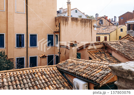 View of rooftops and buildings in a narrow street in Venice during a cloudy day View of rooftops and buildings in a narrow street in Venice during a cloudy day 137803076