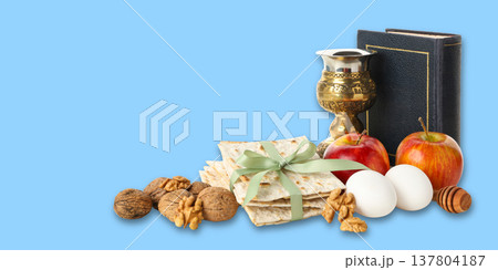 Matzah, apples, eggs, and a cup are arranged for Passover 137804187