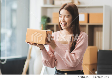 Starting small businesses SME owners female entrepreneurs check online orders to prepare to pack the boxes, sell to customers, sme business ideas online. 137804265