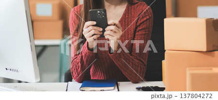 Starting small businesses SME owners female entrepreneurs check online orders to prepare to pack the boxes, sell to customers, sme business ideas online. 137804272