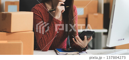 Starting small businesses SME owners female entrepreneurs check online orders to prepare to pack the boxes, sell to customers, sme business ideas online. Starting small businesses SME owners female entrepreneurs check online orders to prepare to pack the boxes, sell to customers, sme business ideas online. 137804273