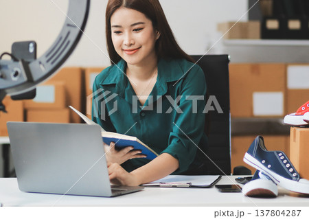 Starting small businesses SME owners female entrepreneurs check online orders to prepare to pack the boxes, sell to customers, sme business ideas online. 137804287