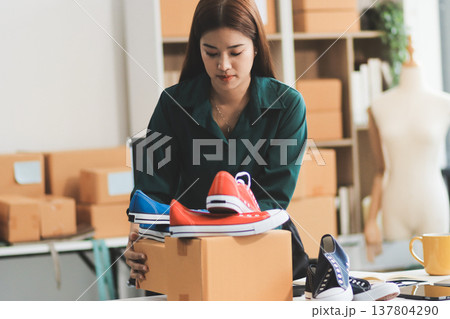 Starting small businesses SME owners female entrepreneurs check online orders to prepare to pack the boxes, sell to customers, sme business ideas online. Starting small businesses SME owners female entrepreneurs check online orders to prepare to pack the boxes, sell to customers, sme business ideas online. 137804290