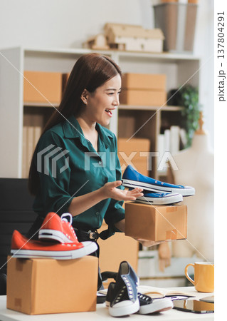 Starting small businesses SME owners female entrepreneurs check online orders to prepare to pack the boxes, sell to customers, sme business ideas online. Starting small businesses SME owners female entrepreneurs check online orders to prepare to pack the boxes, sell to customers, sme business ideas online. 137804291