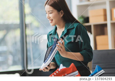 Starting small businesses SME owners female entrepreneurs check online orders to prepare to pack the boxes, sell to customers, sme business ideas online. Starting small businesses SME owners female entrepreneurs check online orders to prepare to pack the boxes, sell to customers, sme business ideas online. 137804293
