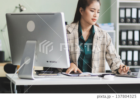 Pain, headache and stressed finance manager feeling sick, tired and worried about a financial problem at her startup company. Young and frustrated professional businesswoman working at an office 137804325