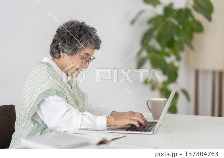 ノートパソコンで作業をする80代の女性 137804763