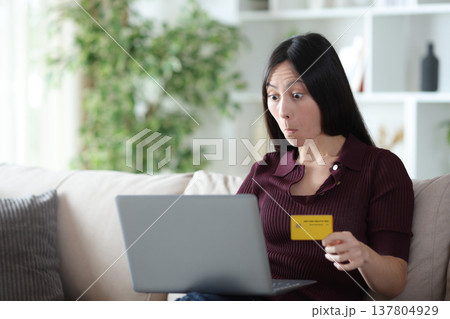 Perplexed asian woman buying online with credit card at home 137804929