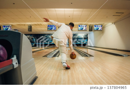Running and throwing a ball. Man is playing bowling indoors Running and throwing a ball. Man is playing bowling indoors 137804965