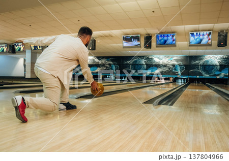 Running and throwing a ball. Man is playing bowling indoors Running and throwing a ball. Man is playing bowling indoors 137804966