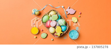 Colorful easter cookies in basket with Multi colors Easter eggs on colored background . Pastel color Easter eggs. holiday concept with copy space Colorful easter cookies in basket with Multi colors Easter eggs on colored background . Pastel color Easter eggs. holiday concept with copy space 137805278