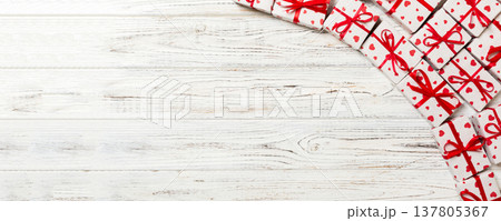 valentine or other holidays concept. Lots of Gift boxes on wood background top view. Presents in craft paper decorated with red ribbon bows and heart. top view with copy space for text frame valentine or other holidays concept. Lots of Gift boxes on wood background top view. Presents in craft paper decorated with red ribbon bows and heart. top view with copy space for text frame 137805367