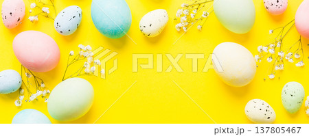 Happy Easter composition. Easter eggs on colored table with gypsophila. Natural dyed colorful eggs background top view with copy space 137805467