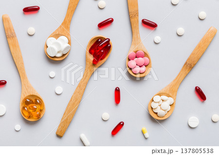 Vitamin capsules in a spoon on a colored background. Pills served as a healthy meal. Red soft gel vitamin supplement capsules on spoon Vitamin capsules in a spoon on a colored background. Pills served as a healthy meal. Red soft gel vitamin supplement capsules on spoon 137805538