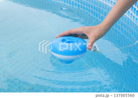 Worker hands isinfection and chlorination of water in the pool. Purification from pollution pool chlor dispenser 137805560