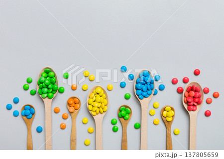 delicious colorful sweet candies on spoon on colored background . Confectionery decor top view with copy space 137805659