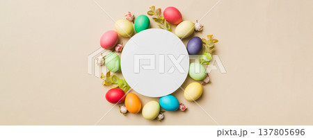 round frame multicolored Easter eggs with white blank paper on a brown background, close-up, space for text, blank for design, selective focus, tinted image 137805696