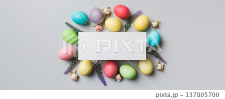round frame multicolored Easter eggs with white blank paper on a brown background, close-up, space for text, blank for design, selective focus, tinted image 137805700