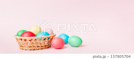 Multi colors Easter eggs in the woven basket on colored background . Pastel color Easter eggs. holiday concept with copy space Multi colors Easter eggs in the woven basket on colored background . Pastel color Easter eggs. holiday concept with copy space 137805704
