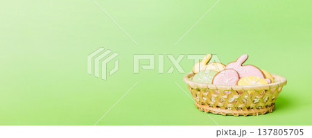 Colorful easter cookies in basket with Multi colors Easter eggs on colored background . Pastel color Easter eggs. holiday concept with copy space Colorful easter cookies in basket with Multi colors Easter eggs on colored background . Pastel color Easter eggs. holiday concept with copy space 137805705