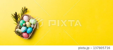 Multi colors Easter eggs in the woven basket on colored background . Pastel color Easter eggs. holiday concept with copy space Multi colors Easter eggs in the woven basket on colored background . Pastel color Easter eggs. holiday concept with copy space 137805716
