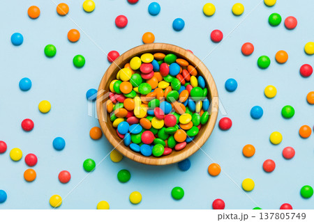 Multicolored candies in a bowl on a colored background. birthday and holiday concept. Top view with copy space Multicolored candies in a bowl on a colored background. birthday and holiday concept. Top view with copy space 137805749