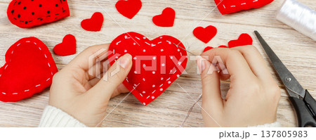 Woman creating red heart on wooden table. gift for St. Valentine's Day handmade Woman creating red heart on wooden table. gift for St. Valentine's Day handmade 137805983