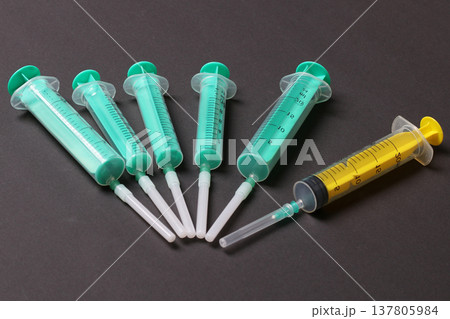 Top view of medical syringes with needles at black background with copy space. Injection treatment concept Top view of medical syringes with needles at black background with copy space. Injection treatment concept 137805984