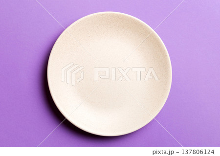 Top view of isolated of colored background empty round beige plate for food. Empty dish with space for your design Top view of isolated of colored background empty round beige plate for food. Empty dish with space for your design 137806124