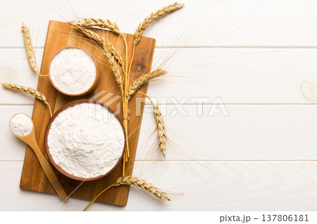 Flat lay of Wheat flour in wooden bowl with wheat spikelets on colored background. world wheat crisis 137806181