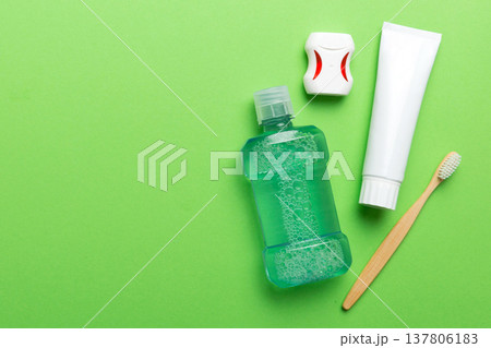 Mouthwash and other oral hygiene products on colored table top view with copy space. Flat lay. Dental hygiene. Oral care products and space for text on light background. concept Mouthwash and other oral hygiene products on colored table top view with copy space. Flat lay. Dental hygiene. Oral care products and space for text on light background. concept 137806183