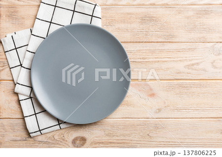 Top view on colored background empty round gray plate on tablecloth for food. Empty dish on napkin with space for your design 137806225