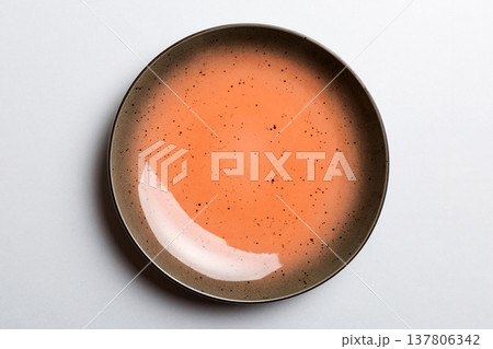 Top view of isolated of colored background empty round orange plate for food. Empty dish with space for your design 137806342
