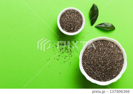 Chia seeds in bowl on colored background. Healthy Salvia hispanica in small bowl. Healthy superfood Chia seeds in bowl on colored background. Healthy Salvia hispanica in small bowl. Healthy superfood 137806366