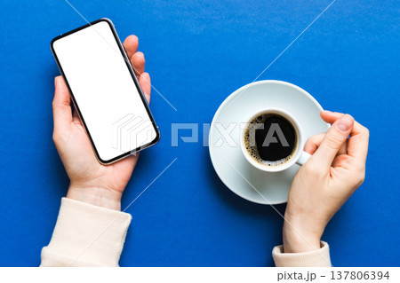 Top view of woman hands holding smart phone with blank copy space screen for your text message or information content. woman hand using phone white screen on top view Top view of woman hands holding smart phone with blank copy space screen for your text message or information content. woman hand using phone white screen on top view 137806394
