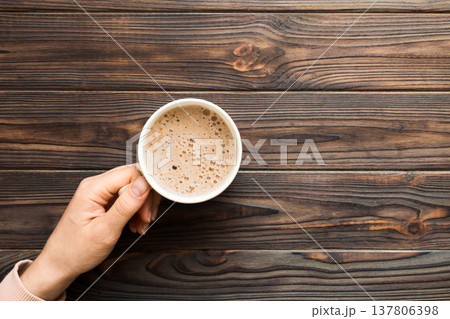 Minimalistic style woman hand holding a cup of coffee on Colored background. Flat lay, top view cappuccino cup. Empty place for text, copy space. Coffee addiction. Top view, flat lay Minimalistic style woman hand holding a cup of coffee on Colored background. Flat lay, top view cappuccino cup. Empty place for text, copy space. Coffee addiction. Top view, flat lay 137806398