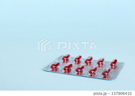 Blister package with Vitamin a on color background. Medicine pills on a light background. Medicines and prescription pills flat lay background. red medical tablets in blister Blister package with Vitamin a on color background. Medicine pills on a light background. Medicines and prescription pills flat lay background. red medical tablets in blister 137806410